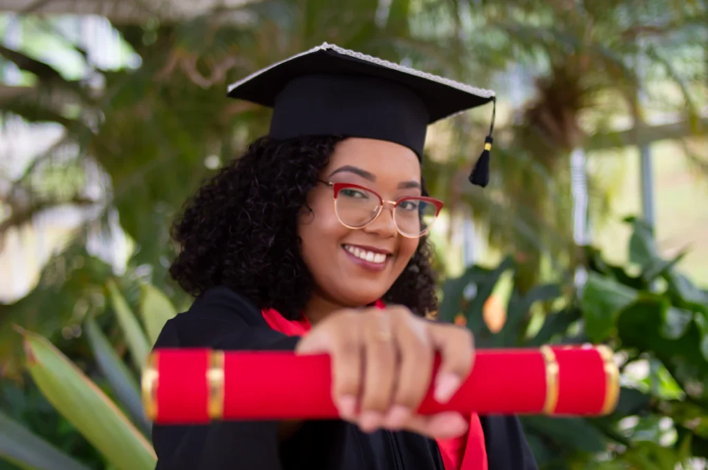 Smiling graduate in academic gown and cap