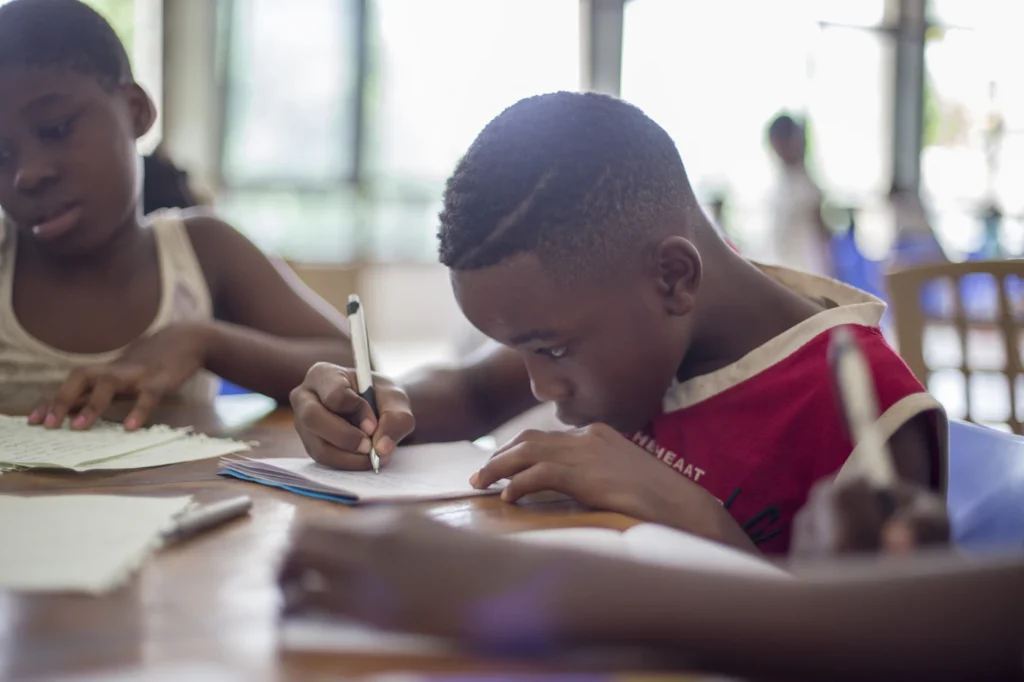 Two pupils writing in their exercise books