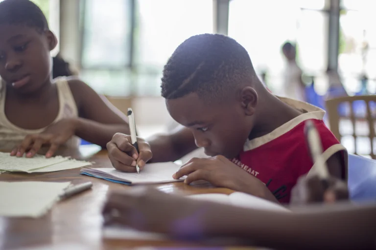Two pupils writing in their exercise books
