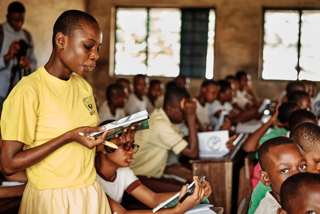 A teacher standing in front of a group of attentive schoolchildren